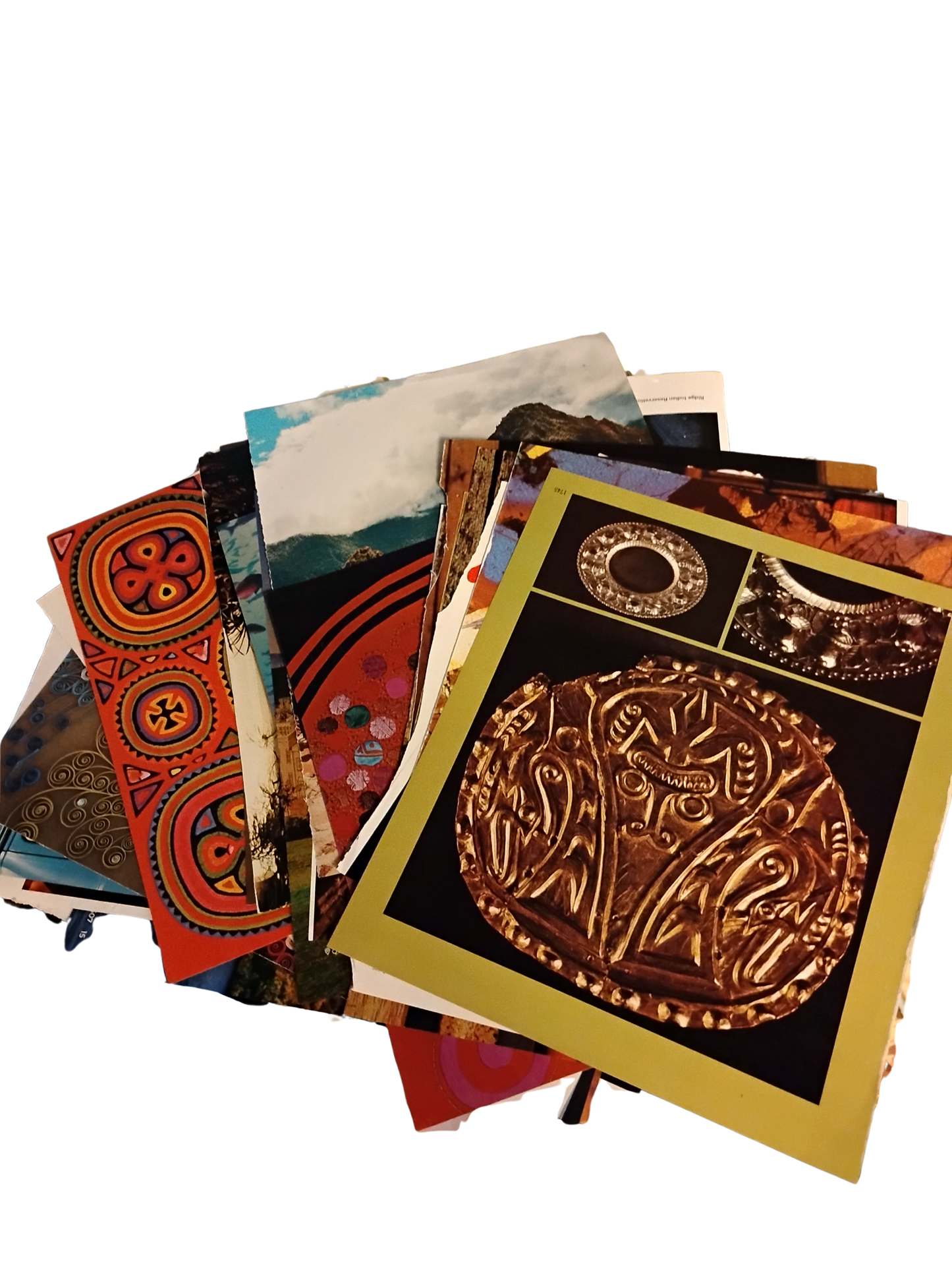 A stack of printed art cards or posters featuring Norse and Viking themes, including a prominent gold-toned illustration of a Viking jöttingr (a carved wooden skull) on a black background with a gold border, alongside other cards showing red, orange, and blue patterns and landscapes.